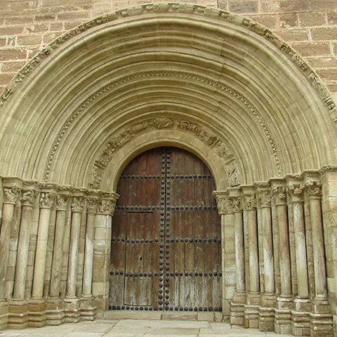 Portada histórica con columnas esculpidas y arco de medio punto.