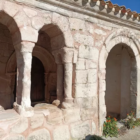 Pórtico de piedra con columnas y capiteles sencillos.