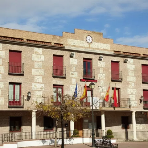 Ayuntamiento de ladrillo con reloj y balcones