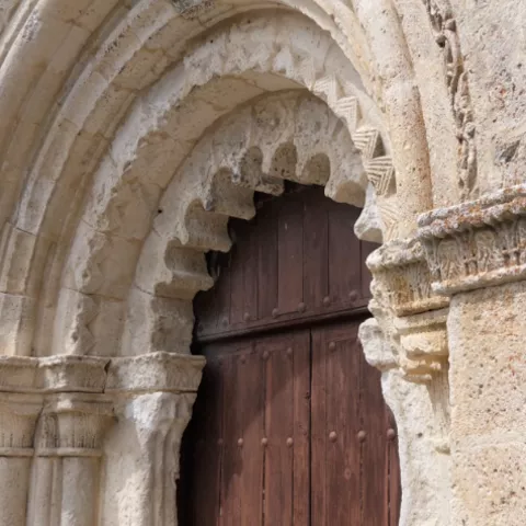 Portada románica con arco decorado.
