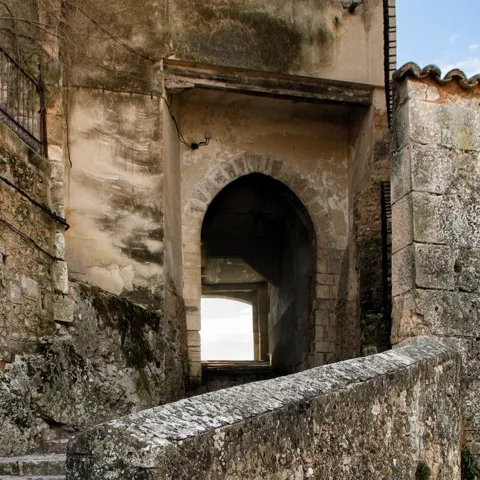 Acceso fortificado con arco y muros antiguos