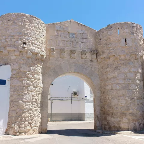 Puerta fortificada de piedra con arco central