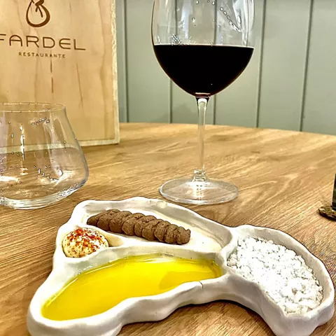 Plato de alta cocina con copa de vino