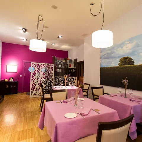 Sala luminosa con manteles rosas y arte contemporáneo