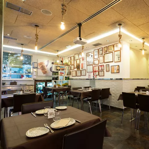 Comedor moderno con cuadros y mesas vestidas