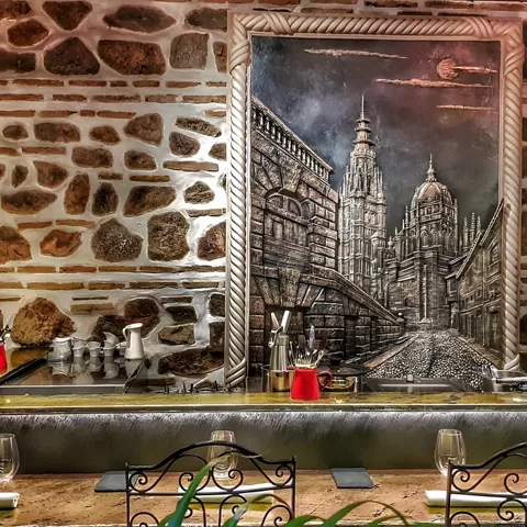 Barra con pared de piedra y gran cuadro urbano en blanco y negro