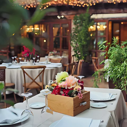 Terraza ajardinada con mesas vestidas y centro floral