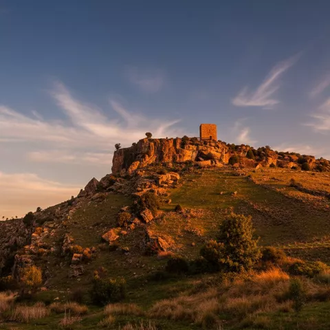 Torre en lo alto de una colina al atardecer