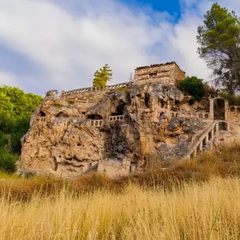 Escalinata de piedra junto a roca horadada.