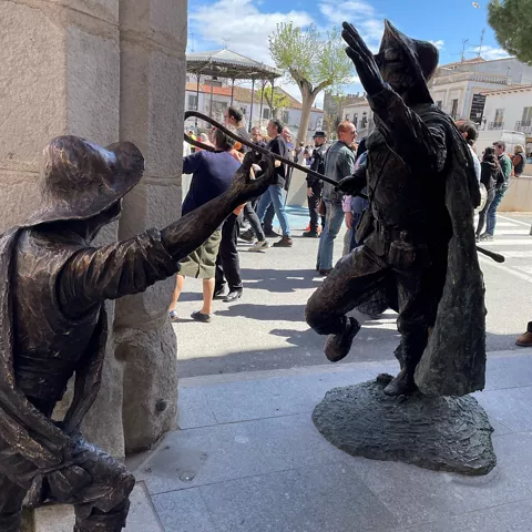 Escena de espadas con dos estatuas de bronce en un pórtico