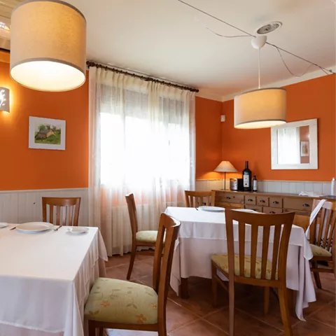 Sala luminosa con mesas cuadradas y decoración sencilla