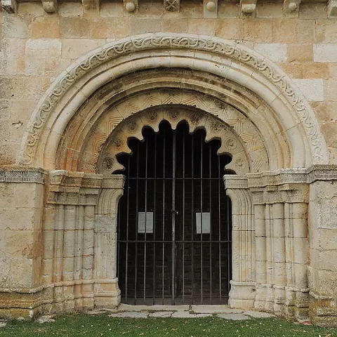 Fachada de piedra con puerta de arco tallado.