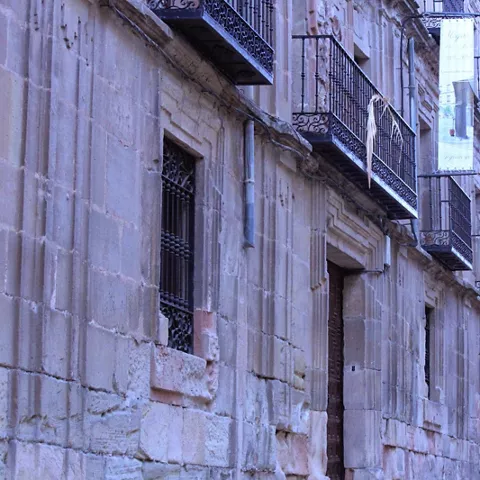 Calle con edificios históricos y balcones de forja.