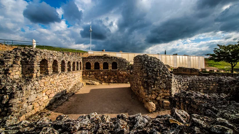 Estructura de baños antiguos con muros de piedra y arcos.