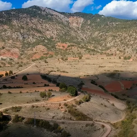 Valle montañoso con caminos y campos de secano