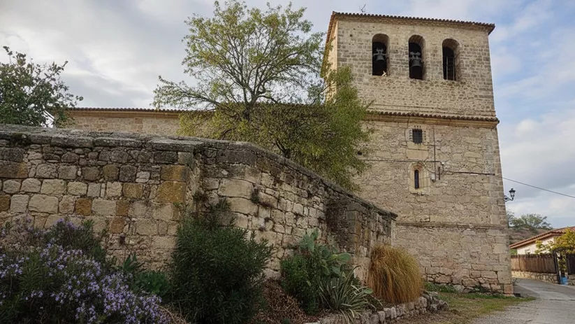 Iglesia de piedra con entorno ajardinado
