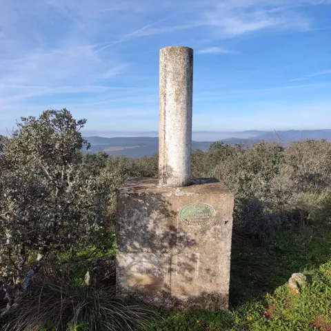 Pilar de hormigón en punto elevado con paisaje al fondo