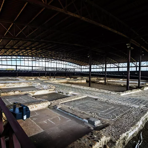 Interior de un espacio cubierto que protege restos arqueológicos y suelos de mosaico.
