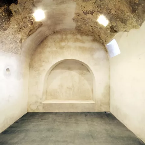 Sala con nicho semicircular en el muro y bóveda iluminada por pequeñas aperturas.