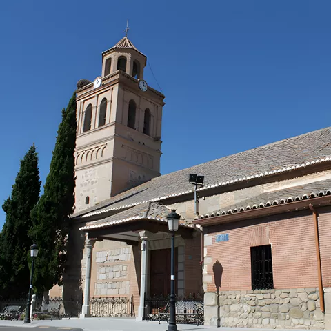 Iglesia de ladrillo y piedra con torre campanario