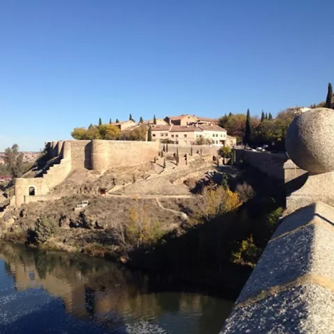 Murallas junto al río vistas desde un puente de piedra