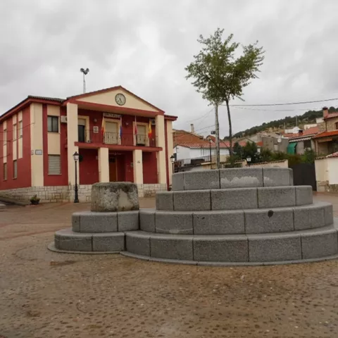 Plaza con fuente circular de piedra y edificio consistorial al fondo