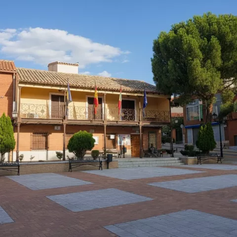 Edificio consistorial con balcones y banderas en la plaza