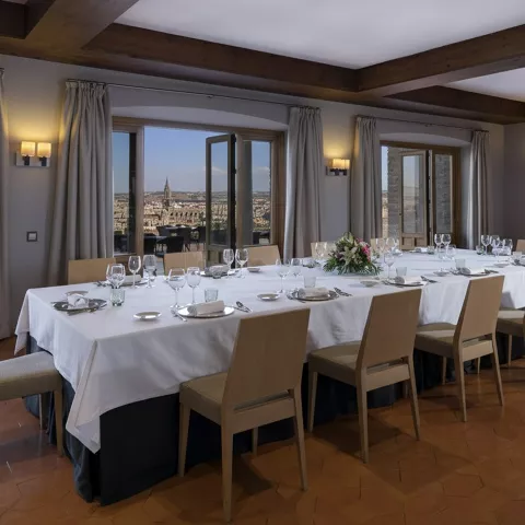 Salón privado con mesa larga y vistas a la ciudad