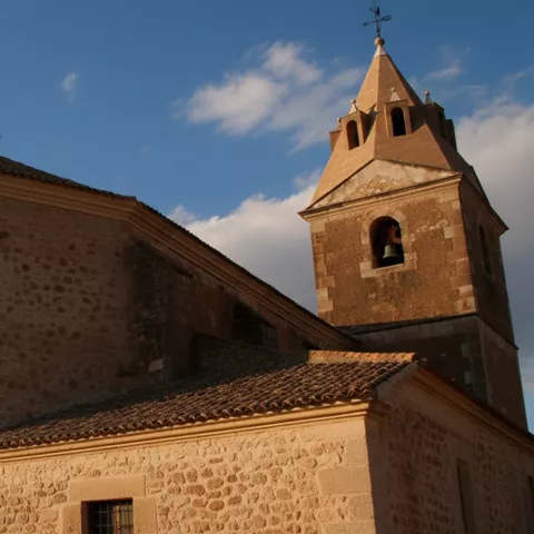 Iglesia de piedra con torre y tejado tradicional