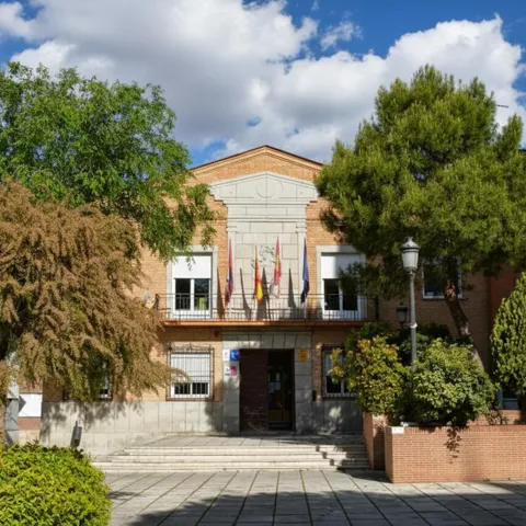 Fachada principal de edificio público rodeado de arbolado