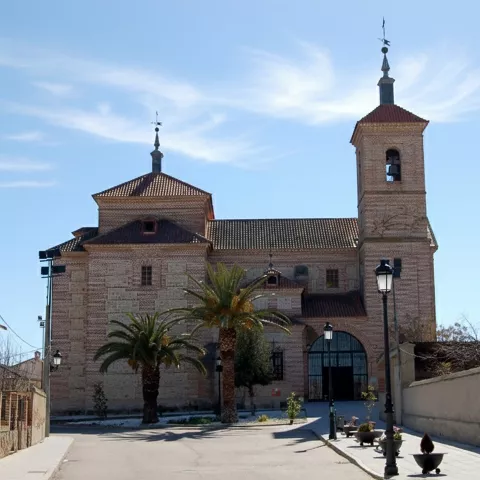 Iglesia parroquial de ladrillo vista desde una calle tranquila