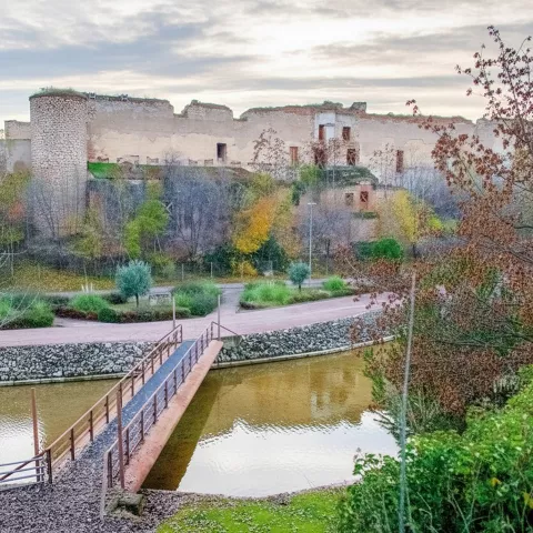 Vista elevada de ruinas junto a canal y pasarela.