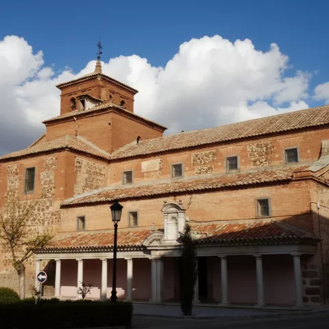 Torre campanario de ladrillo bajo cielo azul