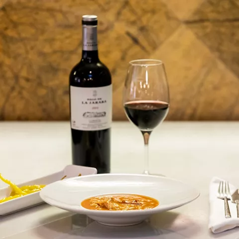 Plato tradicional con vino tinto y guarnición