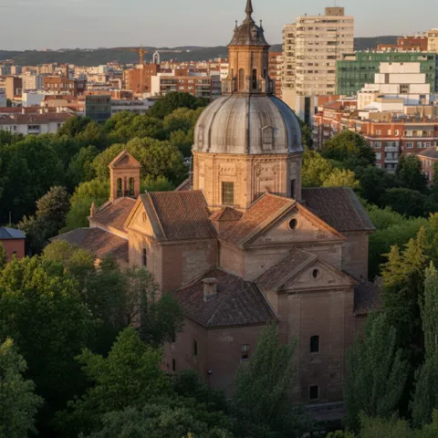 Vista elevada de un templo con cúpula entre árboles, con edificios urbanos al fondo.