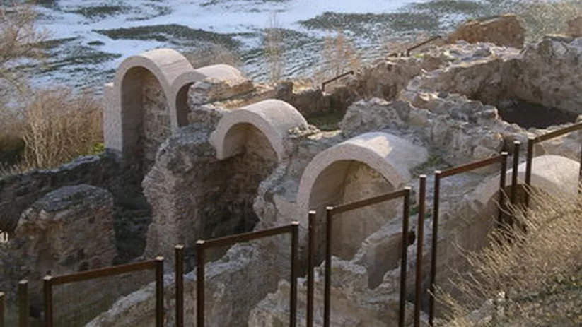 Restos de muros y bóvedas semicirculares en un conjunto arqueológico al aire libre.