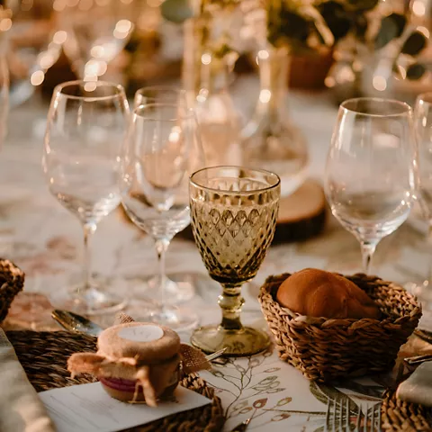 Mesa decorada con copas, pan y centro floral
