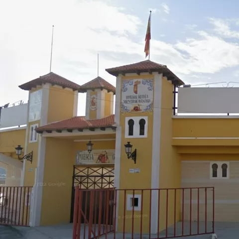 Plaza de toros de estilo tradicional con fachada amarilla