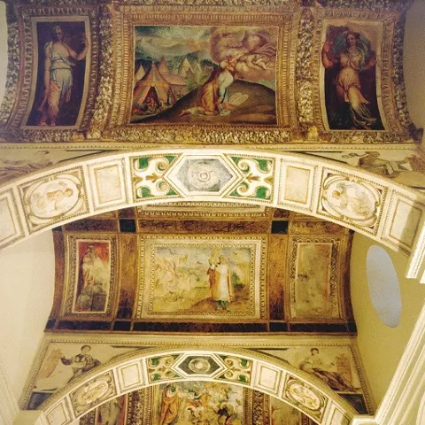 Bóveda decorada con frescos renacentistas y escenas figurativas.