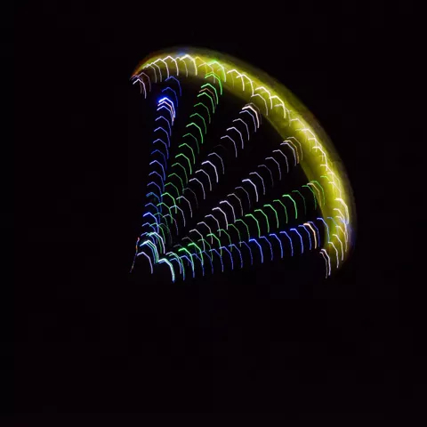 Parapente nocturno con luces de colores en el aire