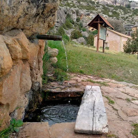 Fuente natural junto a ermita rural.