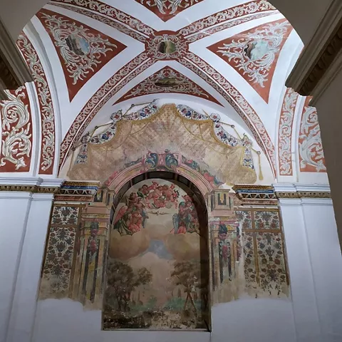 Interior de iglesia con cúpula decorada y presbiterio