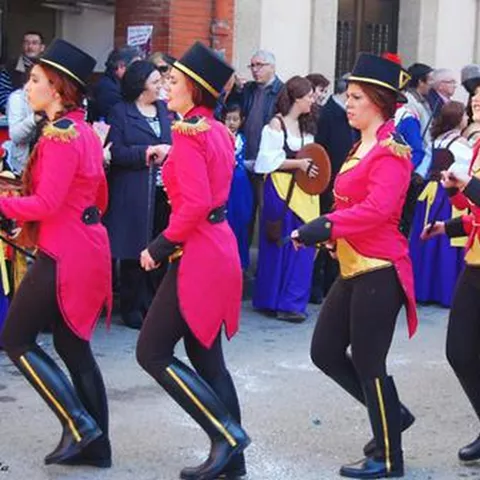 Desfile juvenil con disfraces tradicionales y público alrededor