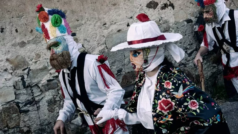 Personajes enmascarados en celebración popular.