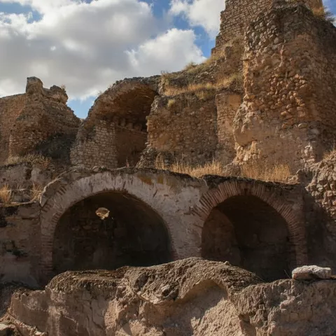 Estructuras y arcos de piedra en el recinto del castillo de Calatrava la Vieja.