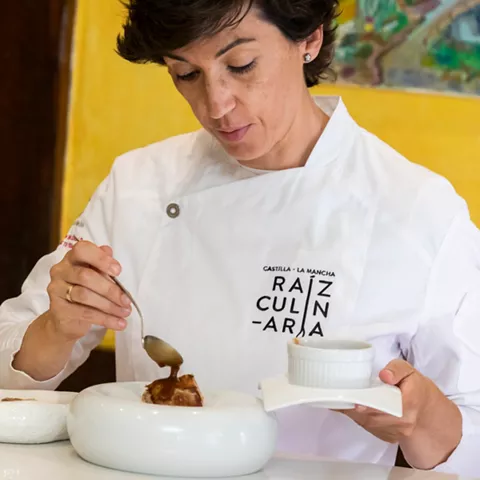 Chef sirviendo salsa sobre carne