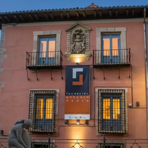 Visitantes observando obras en galería blanca.