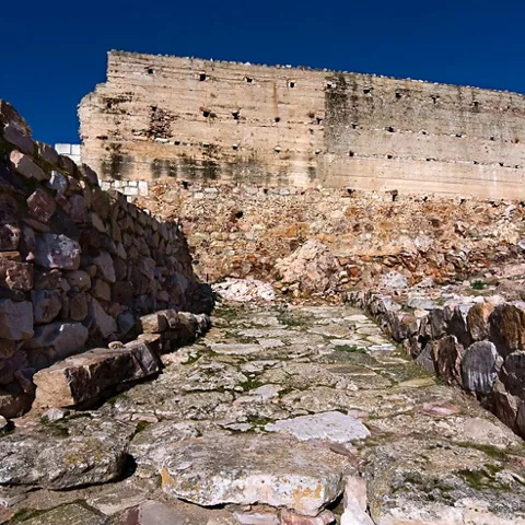 Acceso empedrado entre muros antiguos de una fortificación