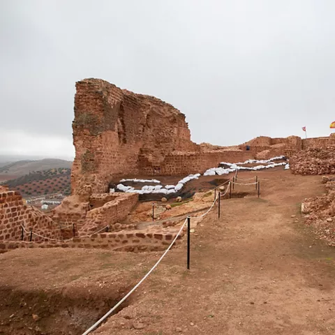 Camino interior entre muros de piedra y estructuras arqueológicas