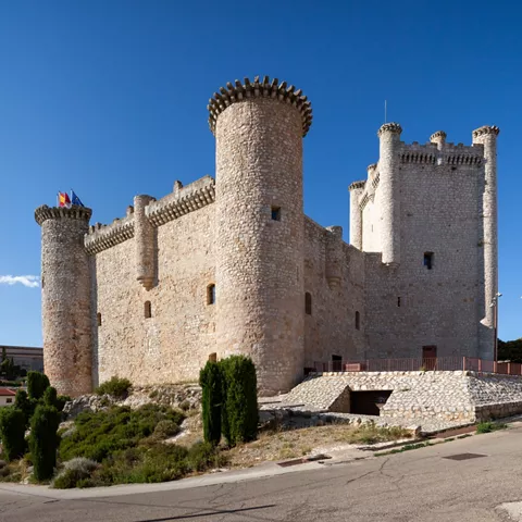 Fortaleza de piedra con torres circulares.